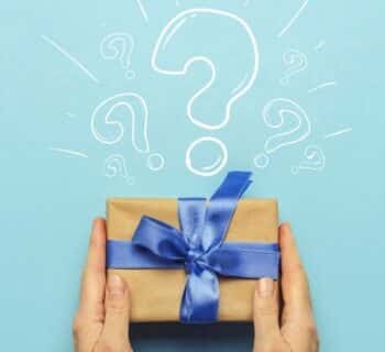 A paper-wrapped gift with a blue bow with a question mark above it.