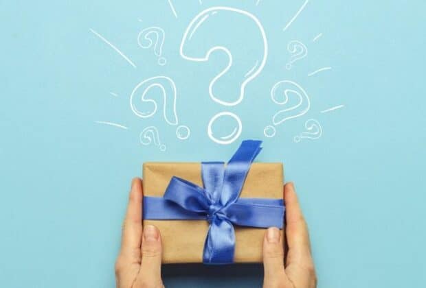 A paper-wrapped gift with a blue bow with a question mark above it.